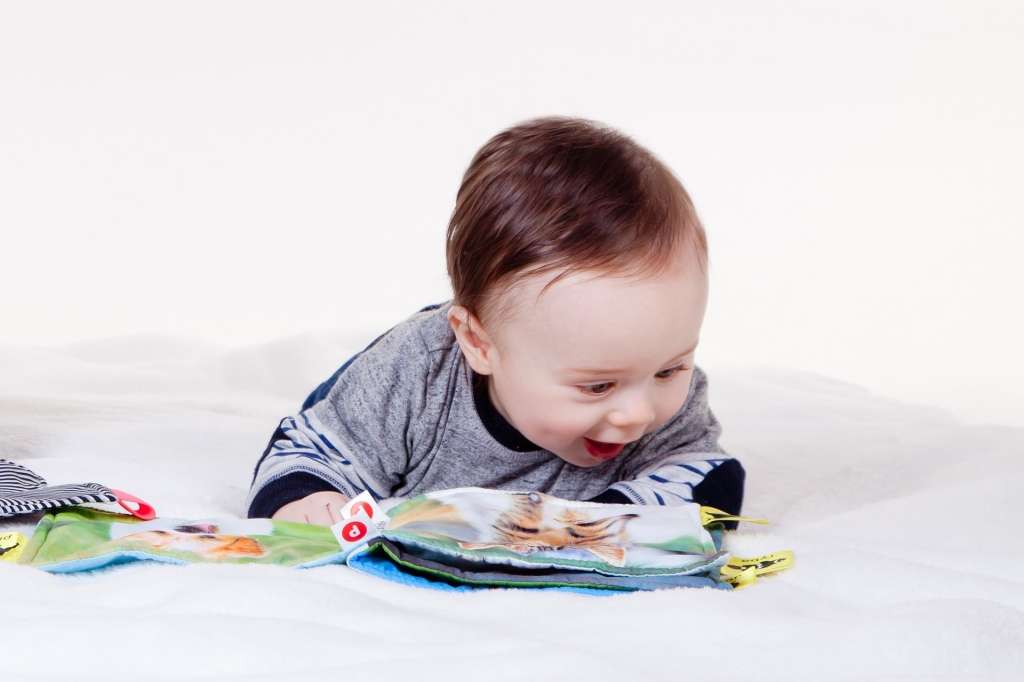 Hoe maak je kind slim. baby kijkt in babyboekje.